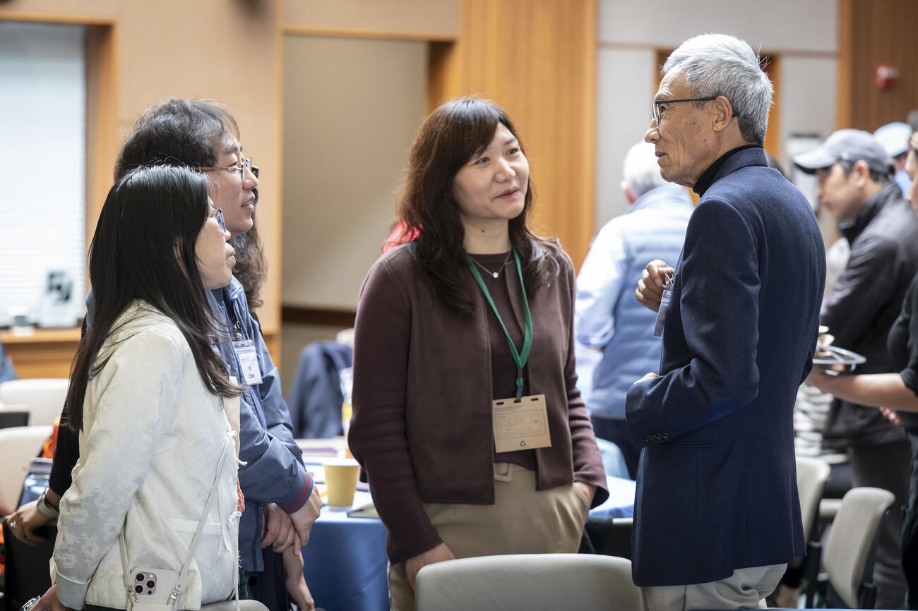 Xiaonian Xu speaks with members of the audience during a break in the conference.