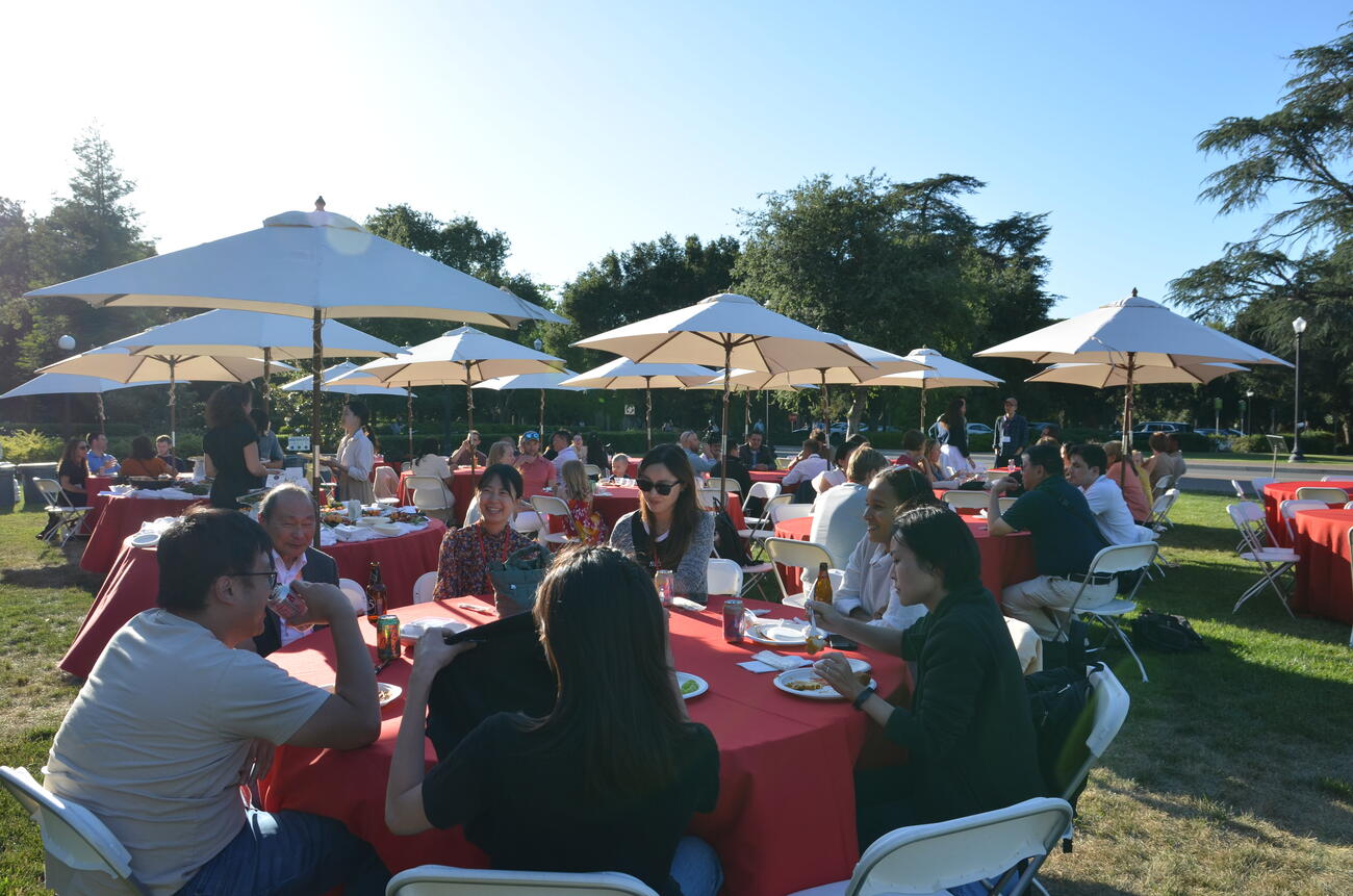 A gathering of alumni from the Ford Dorsey Master's in International Policy eat and mingle on the front lawn of Encina Hall at Stanford University.