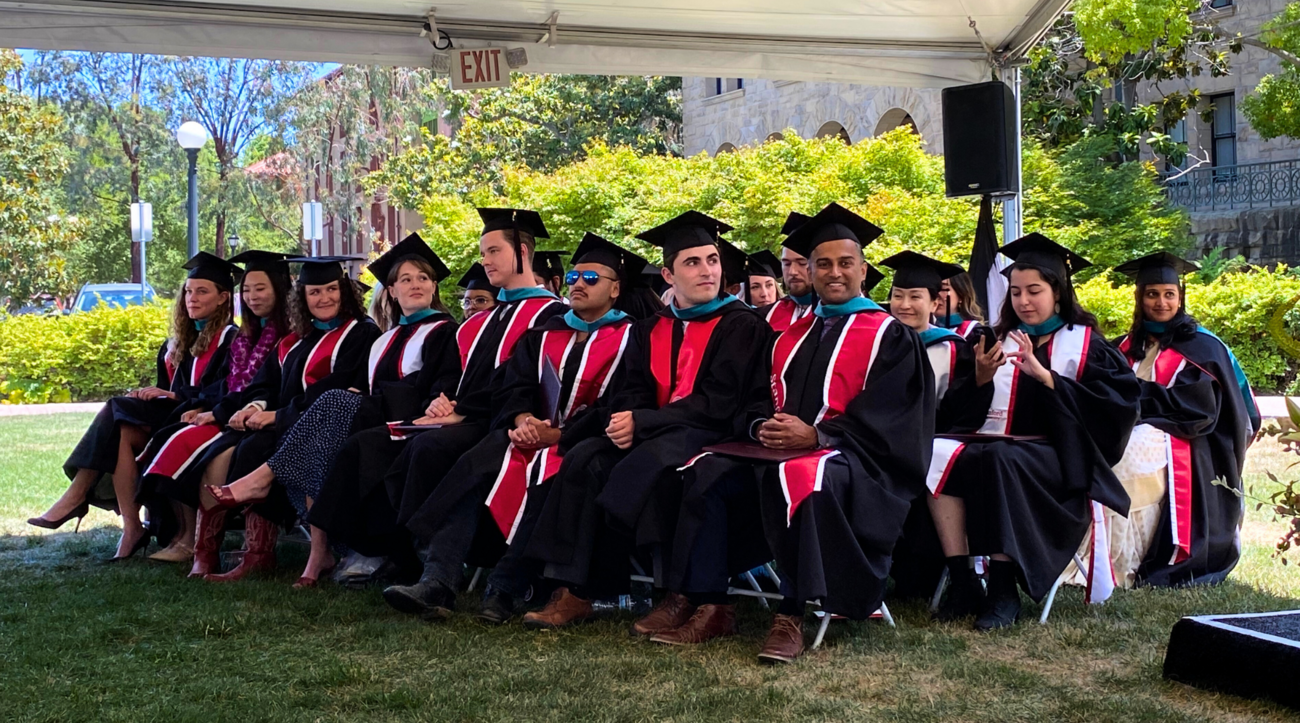 The Class of 2025 of the Ford Dorsey Master's in International Policy sitting together at their graduation ceremony on the lawn of Encina Hall at Stanford University. 