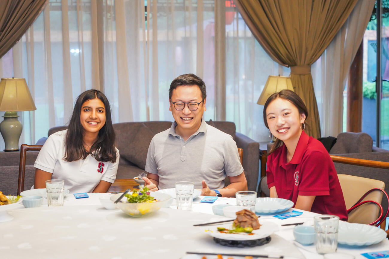 Students pose at a dinner table in China.