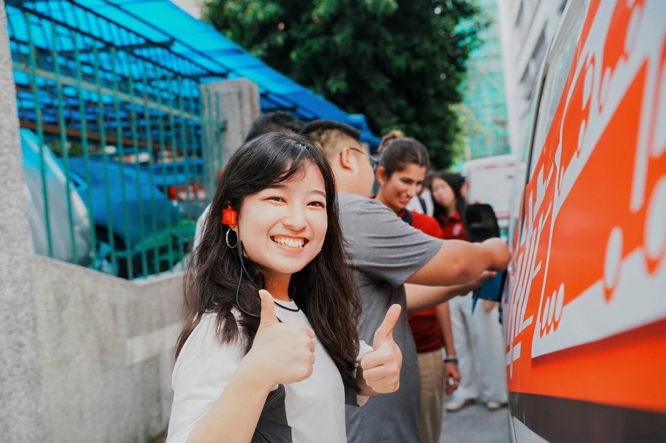 A student gives the camera a double thumbs up.