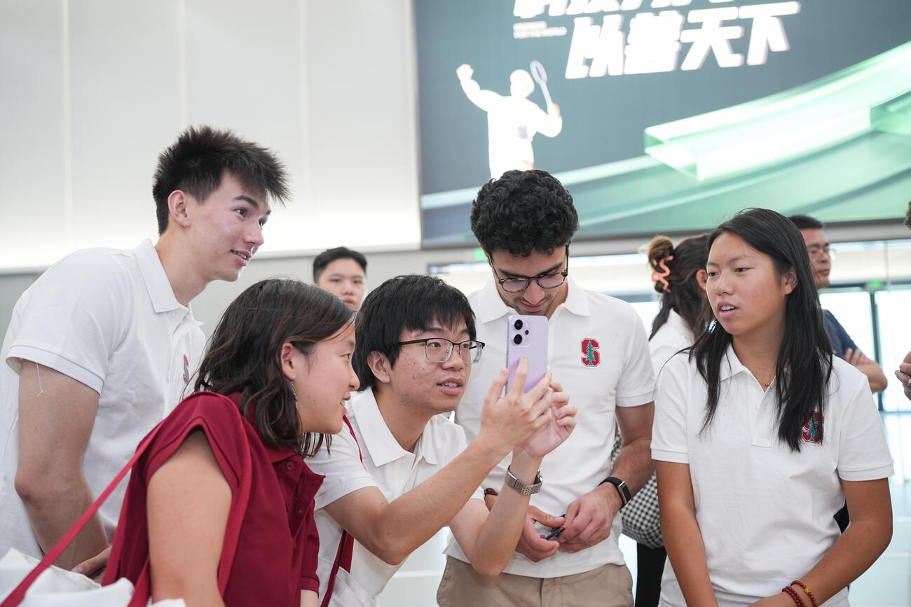 Students look a a phone together.