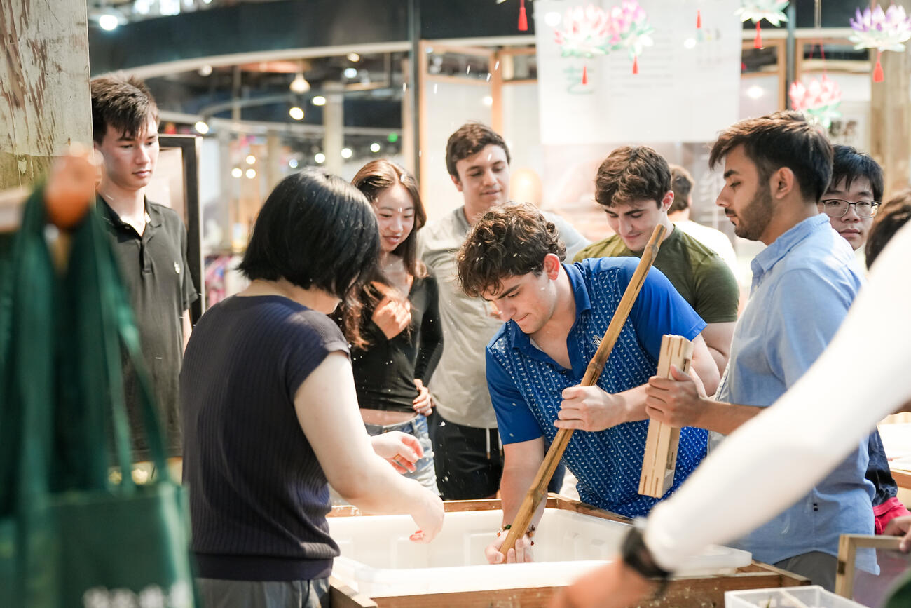 Studnets stir a large pot.