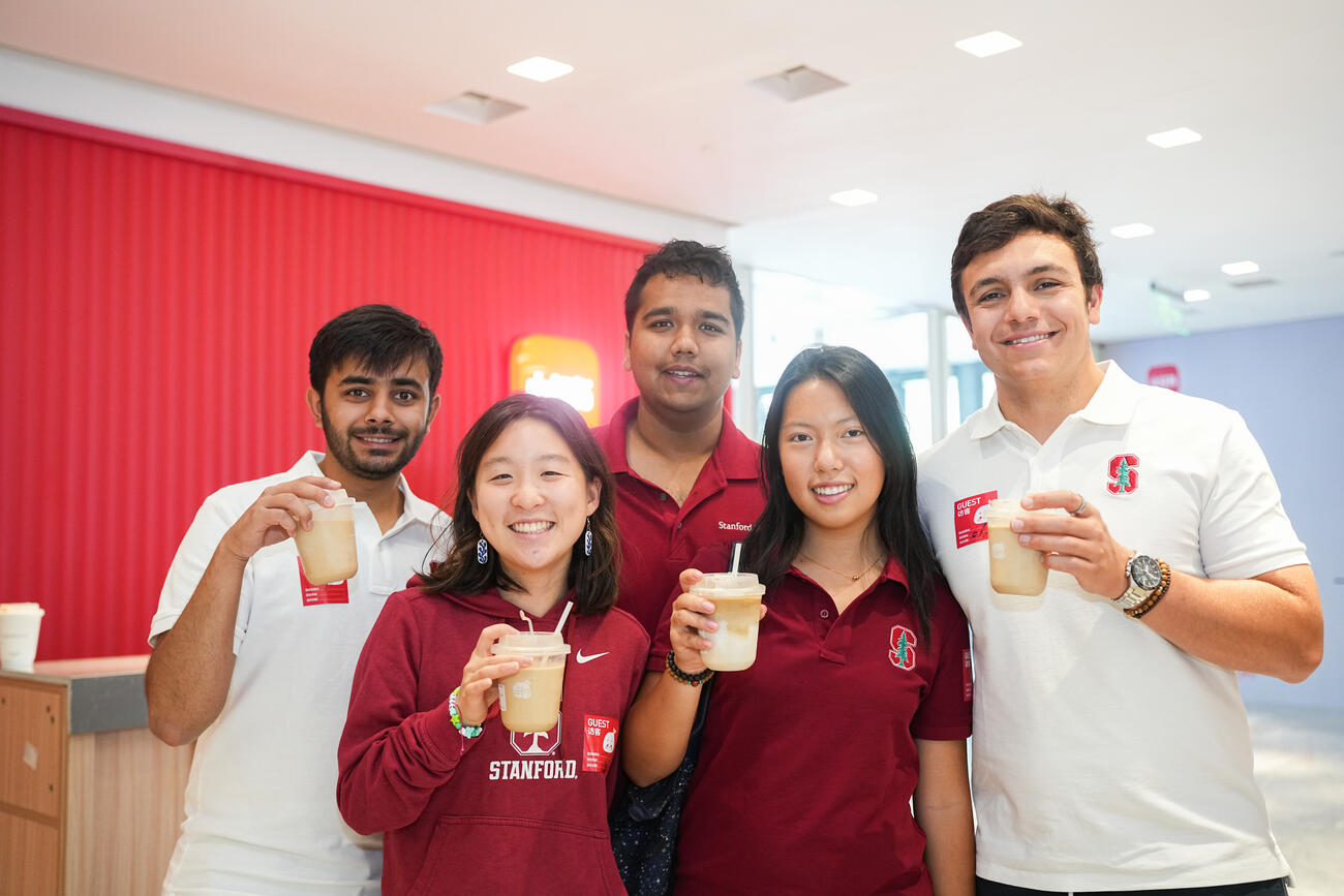 Students pose with coffee drinks.