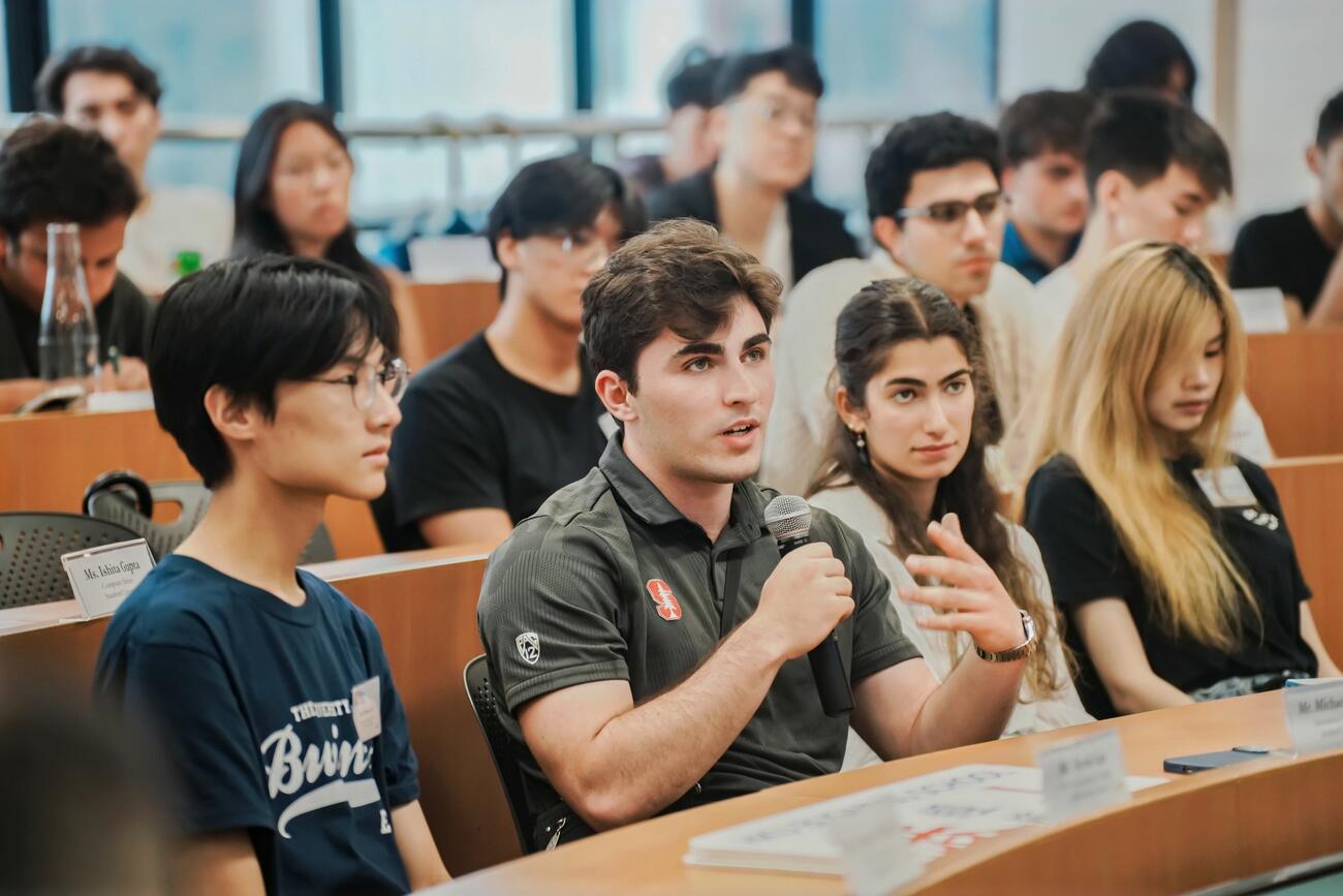 Student discusses while seated in a classroom.