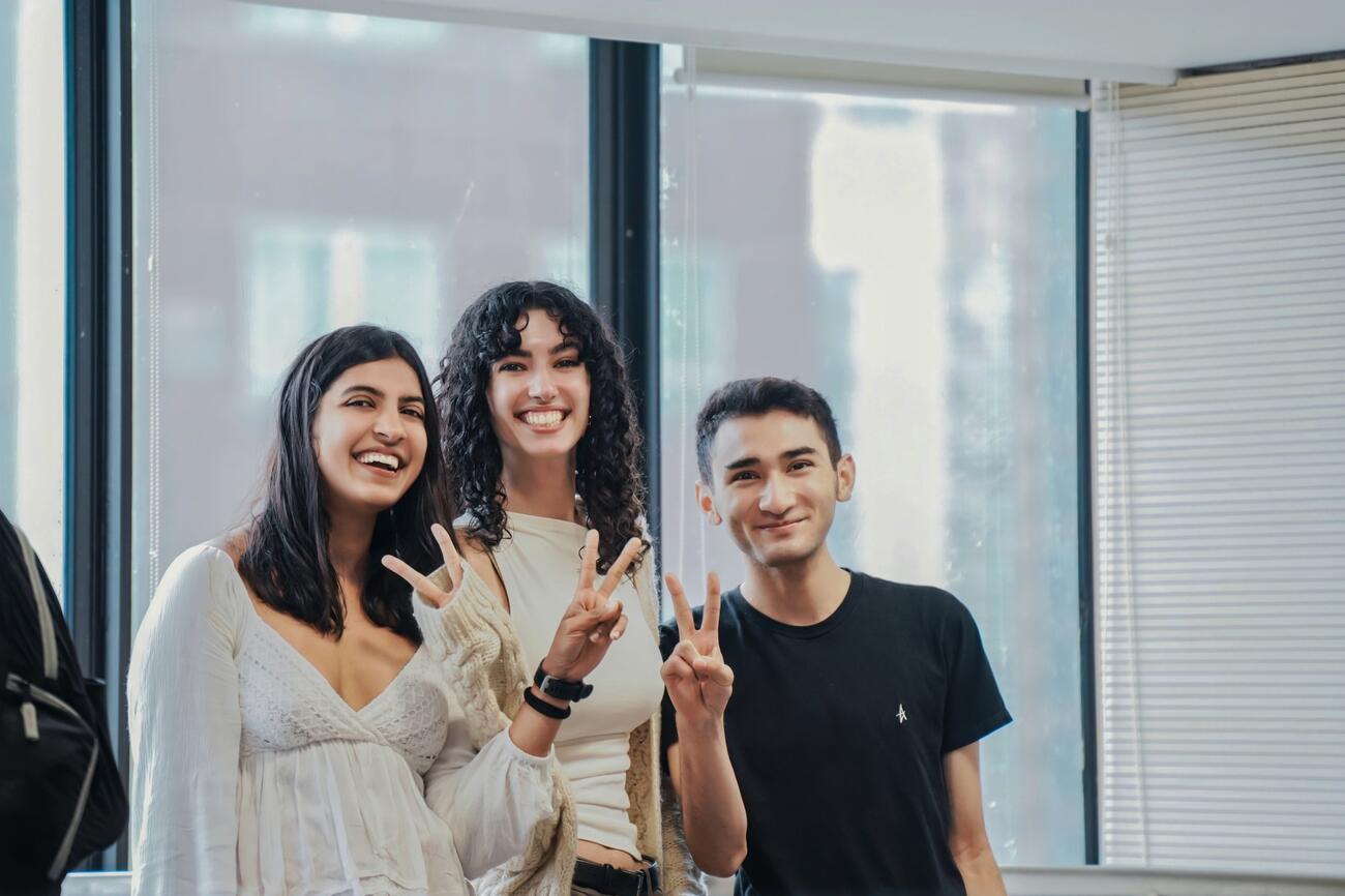 Smiling students with peace signs.