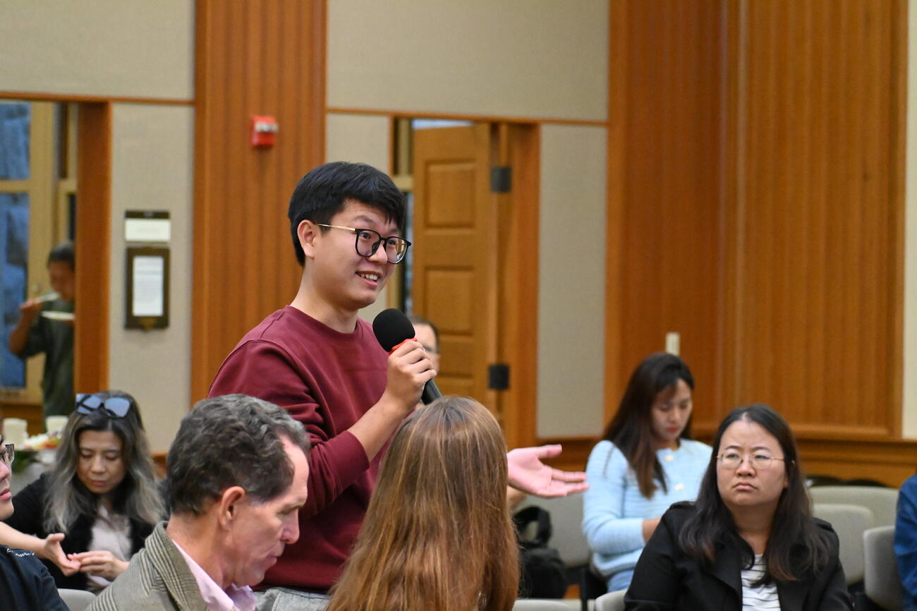 A student asks a question from the audience of an event.
