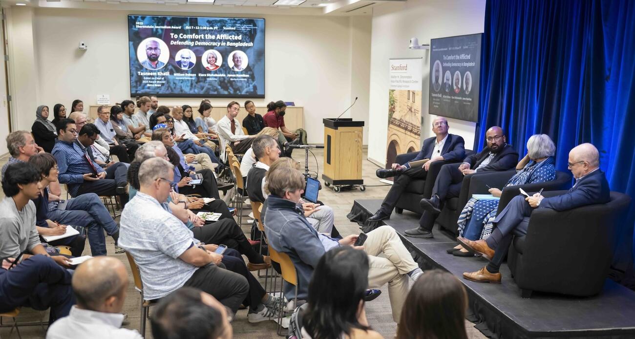 Audience members listening to a panel discussion.