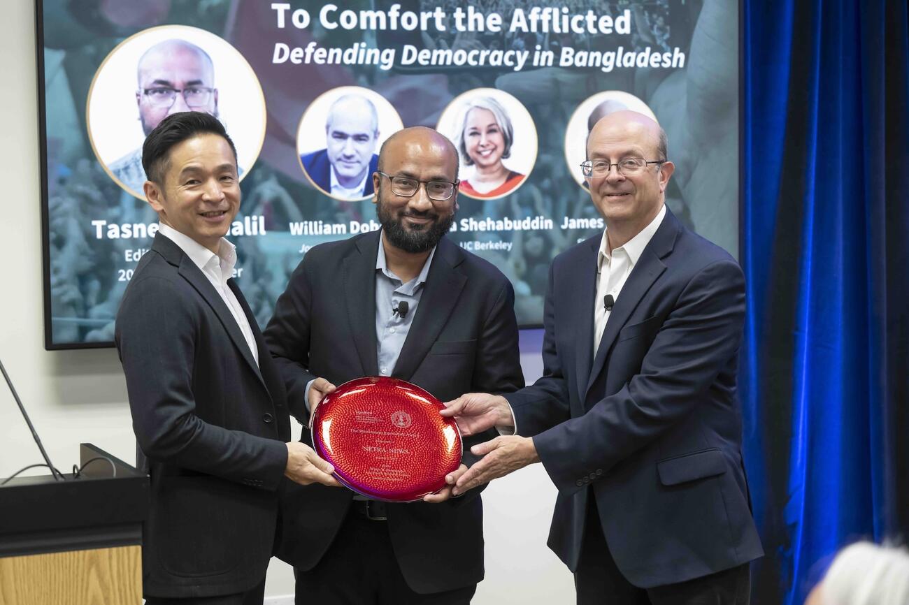 Kiyoteru Tsutsui and James Hamilton present Tasneem Khalil with the 2025 Shorenstein Journalism Award plaque.