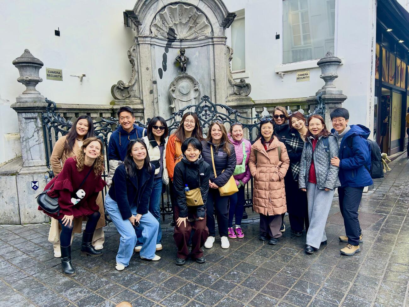 A group poses in front of a fountain in Brussels.