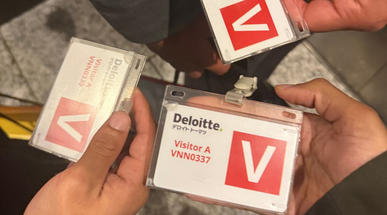 MIP students display their visitor badges to the Deloitte company in Japan.
