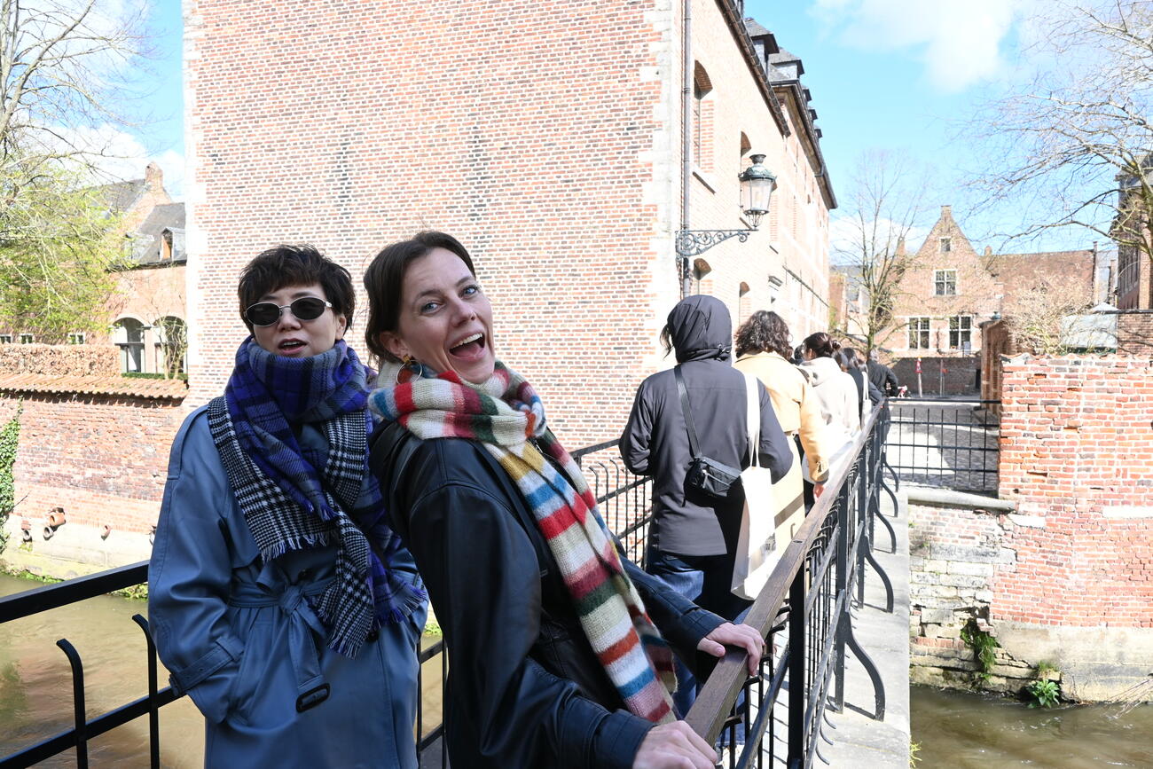 Two women smile during a walking tour in Leuven.