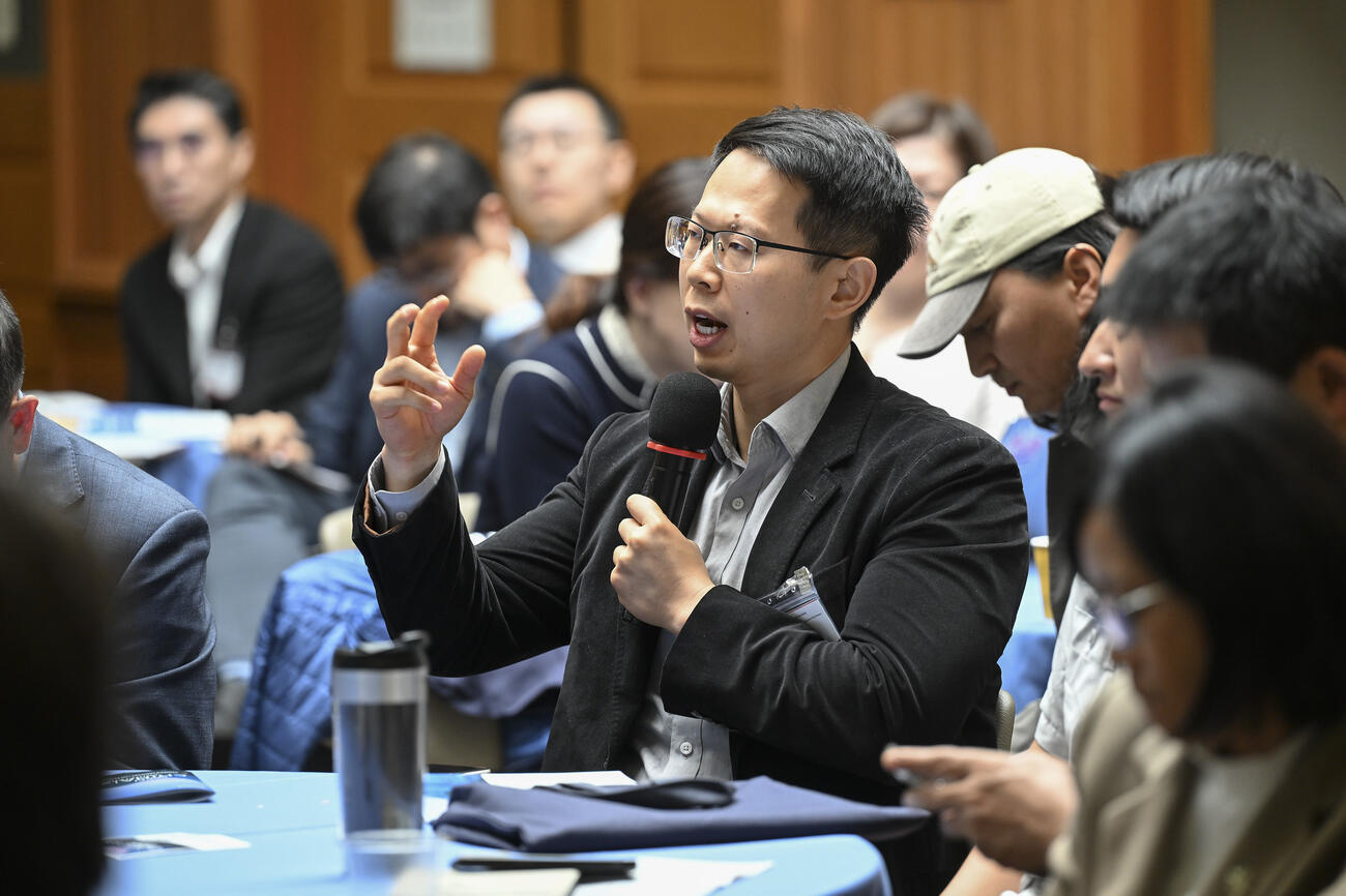 An audience member speaks into a handheld mic.