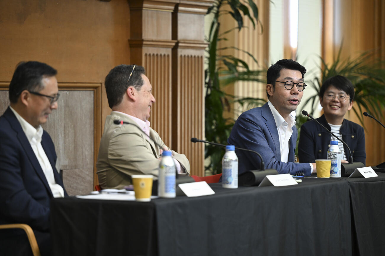 Four people sit behind a table during a panel discussion.