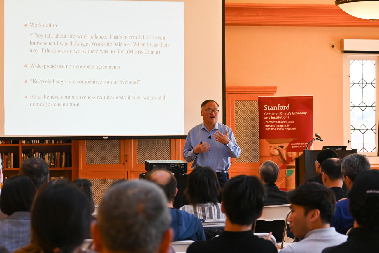 Chang-Tai Hsieh speaks during a lecture in a library. 