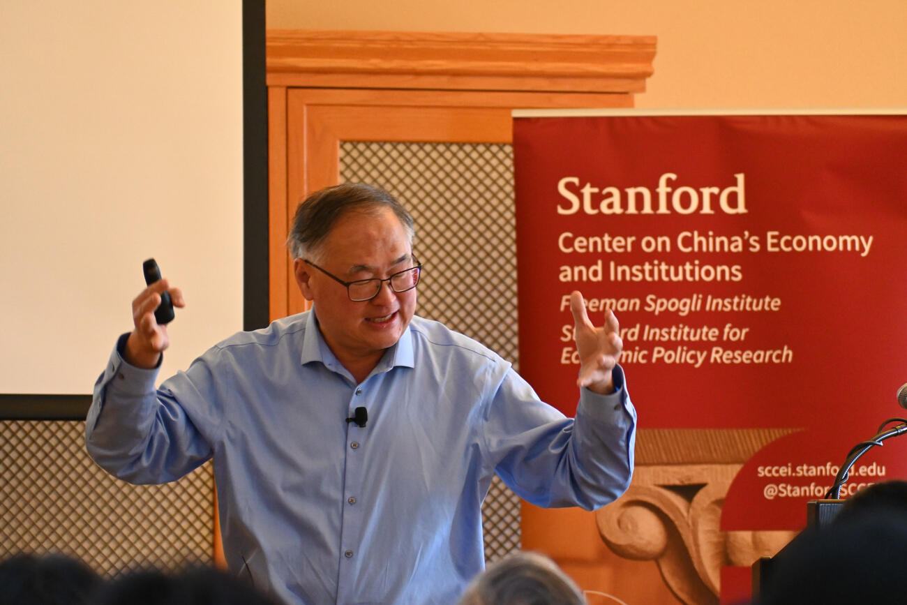 Chang-Tai Hsieh speaks during a lecture in a library. 
