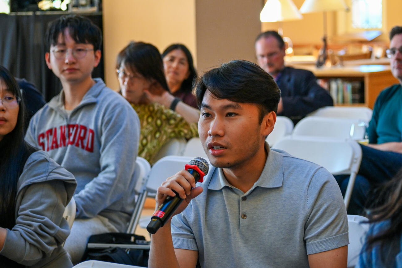 An audience member speaks into a handheld mic.