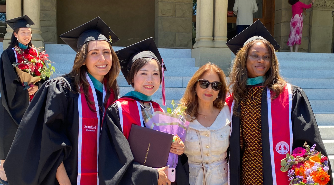 Graduates from the Ford Dorsey Master's in International Policy Class of 2026 pose together near the steps of Encina Hall at Stanford University.