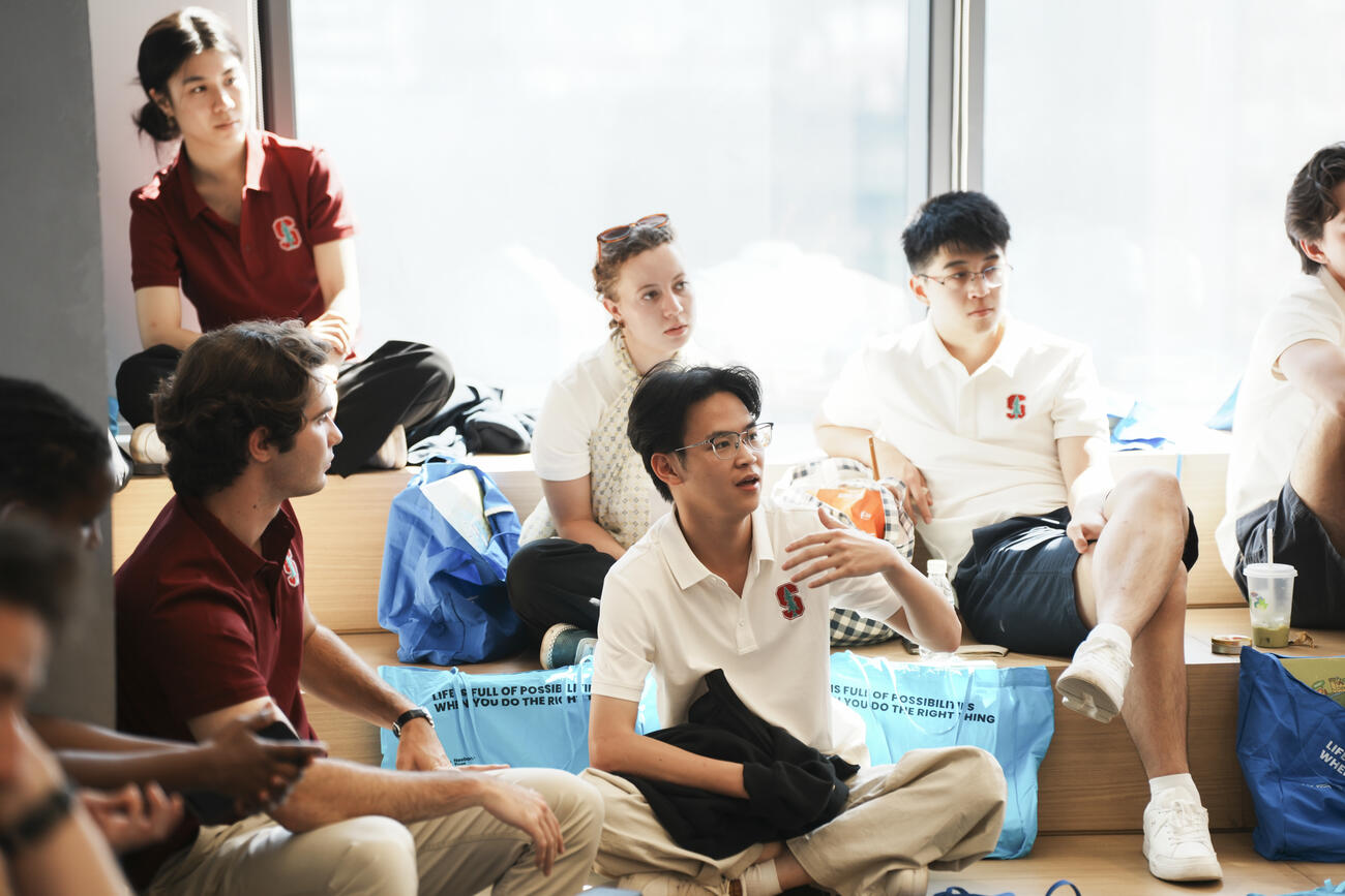 Students sit on steps in conversation. 