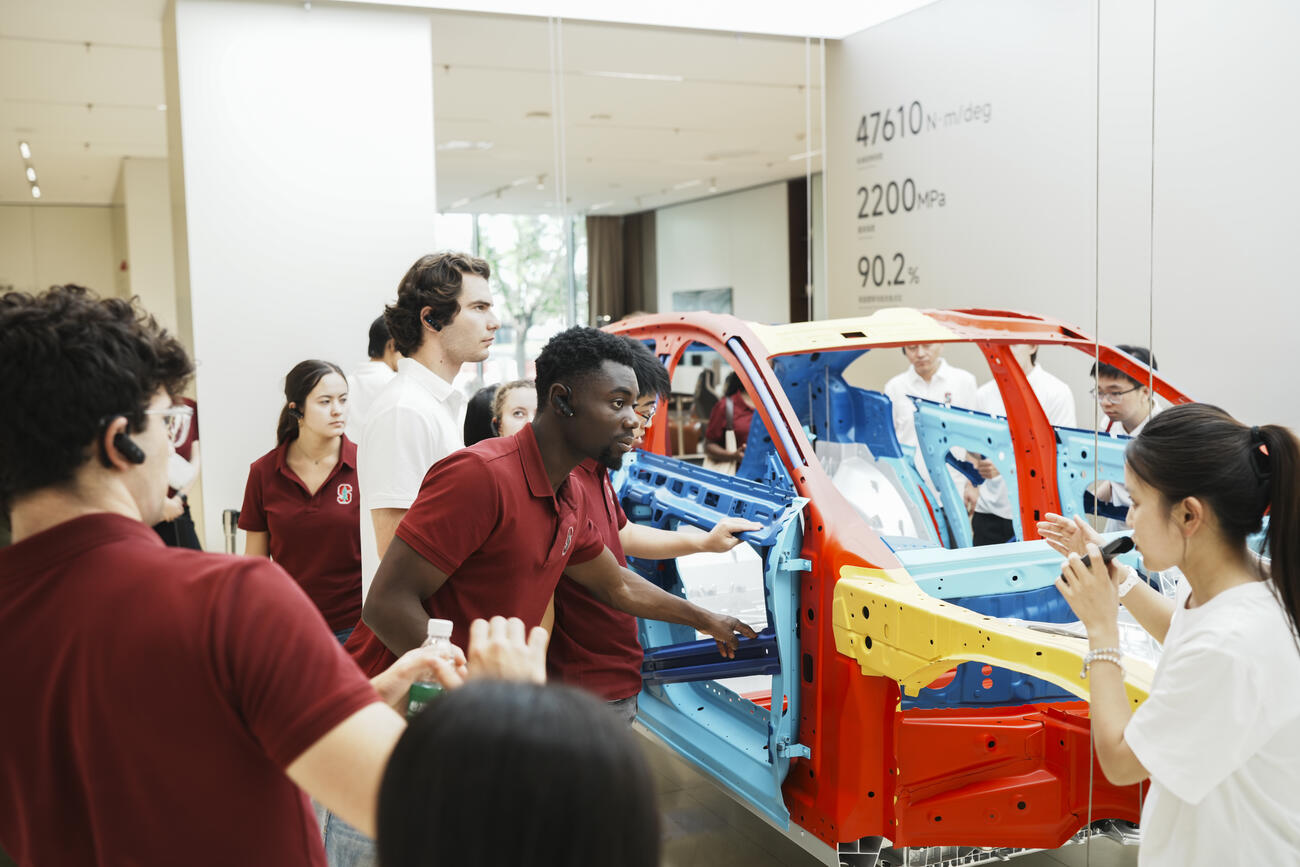 Students look into a model xiaomi car. 