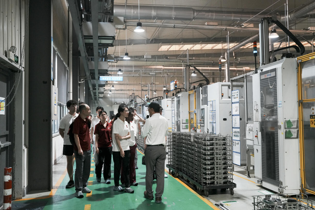 Students walk on the floor of the Shuanhuan factory.