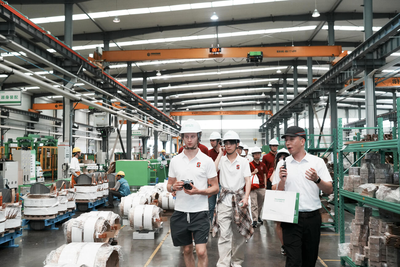 Students walk through the TGOOD factory floor.