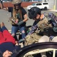 People in miltary gear rendering medical aid