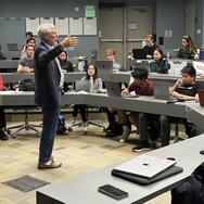 Man lectures before a clasroom
