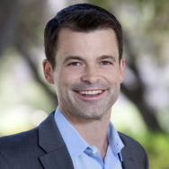 Rob Willer smiling at the camera wearing a blue shirt 