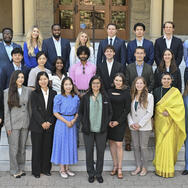 The class of 2027 of MIP students standing on the steps in front of Encina Hall at Stanford University.