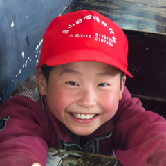 Happy school boy in rural classroom in China.