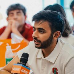 Ankush speaks at a microphone while seated.