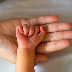 Photo of a mother holding baby's hand