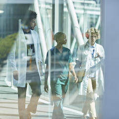 A photo of three doctors walking in a hospital