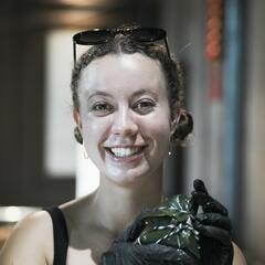 Kristine poses while holding a wrapped zongzi dumpling.