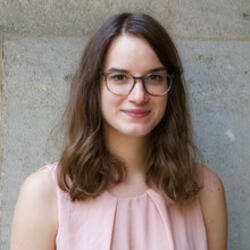Anja Stevic smiling, wearing a pink shirt and glasses