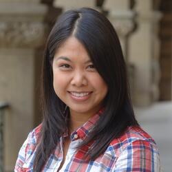 Employee in front of pillars on campus