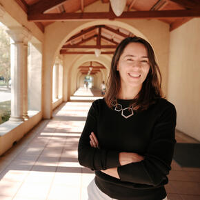 Stanford's Maria Polyakova stands amid the university's sandstone columns.
