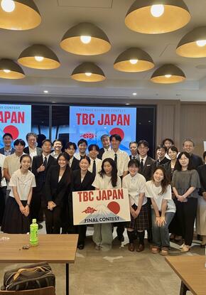 a group of students standing with signs, "TBC Japan"