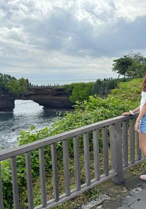 a person standing in front of Tanah Lot