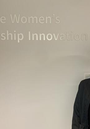 a student posing in front of a sign