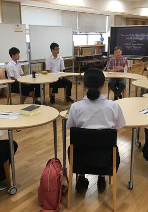 students and an instructor sitting in a circle in a classroom