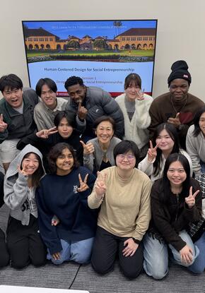 group of students posing in front of a screen