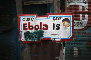 A sign, originally saying "Ebola is Real," hangs defaced in the West Point township on February 1, 2015 in Monrovia, Liberia. Early in the epidemic, many residents of the seaside slum believed the epidemic was a hoax. cdc ebola sign getty images