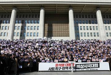 Lawmakers and members of the South Korea's main opposition Democratic Party (DP) demonstrate against the country's president at the National Assembly on December 04, 2024 in Seoul, South Korea. 