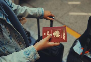 Woman holding Russian passport with luggage