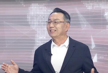 Gi-Wook Shin in a TV studio, speaking during an interview with Arirang TV.