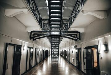 Prison corridor with jail cells on either side.