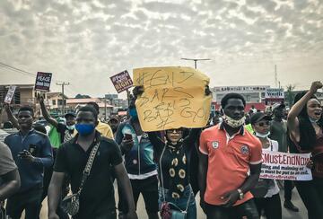 Group of people protesting in Ibadan, Nigeria, holding a sign reading "#EndSARS #EndBadGov"