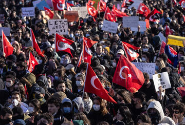 Protesters chant slogans during a protest march holding Turkish flags